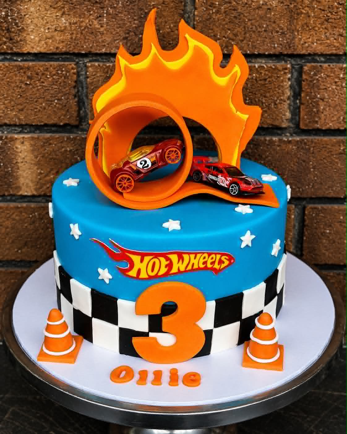 Hot Wheels birthday cake for Ollie with blue fondant, checkered border, loop track and car toppers